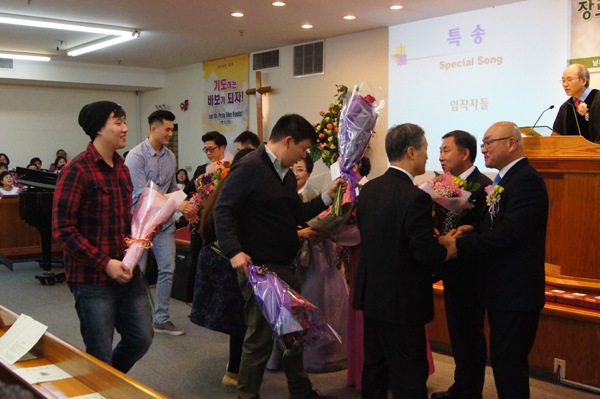 임직자들이 특송에 앞서 꽃다발을 선물받고 있다.