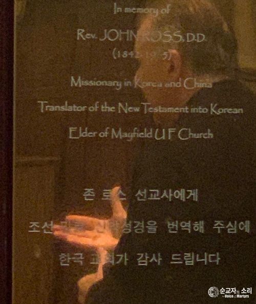 존 로스를 기념하는 명판에 비친 에릭 폴리 목사의 모습. 이 명판은 스코틀랜드 에든버러에 있는 메이필드 솔즈베리 교회에 부착되어 있다. 존 로스는 중국에서 돌아온 뒤에 이 교회에서 장로로 이 교회를 섬겼다.