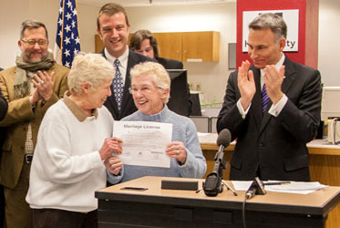 워싱턴주 첫번째 동성결혼 증명서를 발급받은 제인 애보트(Jane Abbott 좌)와 35년 동안 그녀의 파트너였던 피트-E 피터슨(Pete-e Petersen 85, 우)를 다우 콘스탄틴 킹카운티 군수가 축하하고 있다.