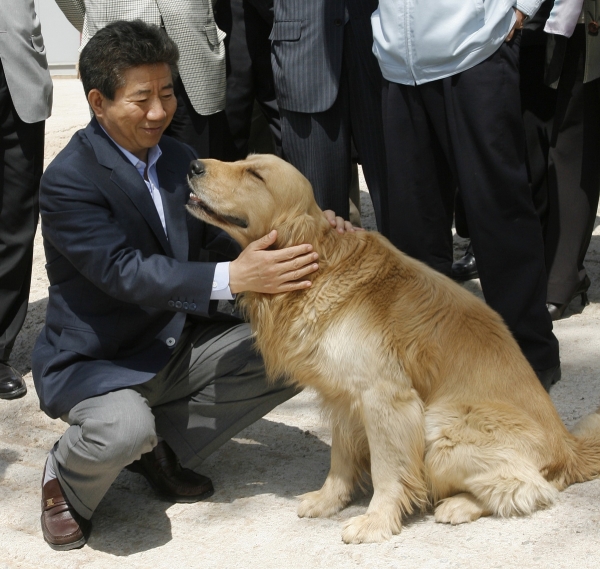2007년 5월 13일 휴일을 맞아 고향 봉하마을을 방문한 노무현 대통령이 마을 어귀에서 개를 쓰다듬으며 미소 짓고 있다.