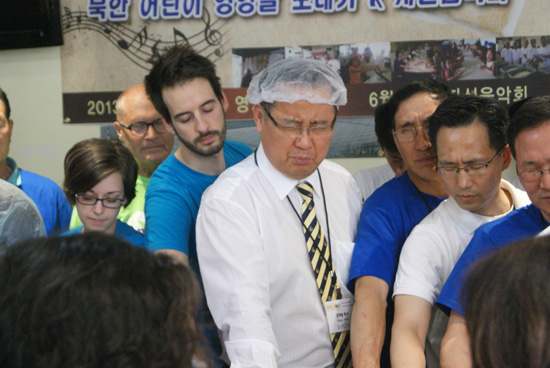 기도하는 김재열 목사와 자원봉사자들