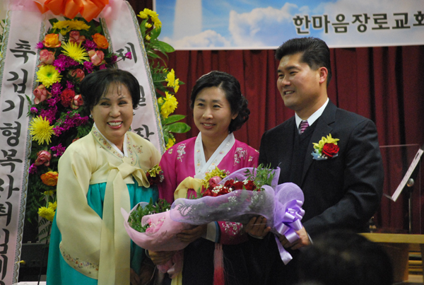 김기형 담임목사 부부가 축하 꽃다발을 받고 있다.