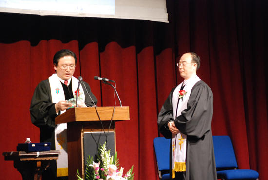 김홍채 목사가 박상돈 목사에게 위임패를 전달하고 있다.