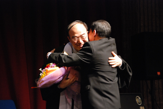 박상돈 목사,이태호 장로가 꽃다발 전달식을 갖고 포옹하고 있다. 
