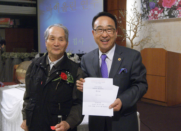 한약교환권을 어르신에게 전달하고 있는 김영환 목사