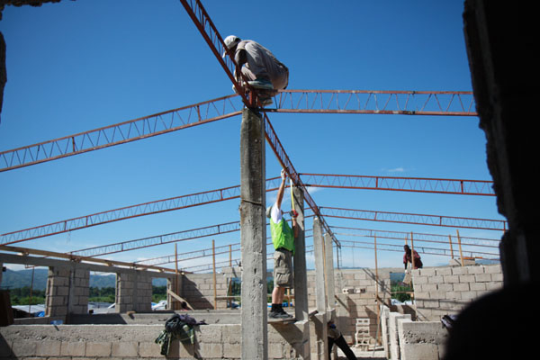 단기선교팀이 비지땀을 흘리며 아이티 현지에 건물을 세우고 있다.