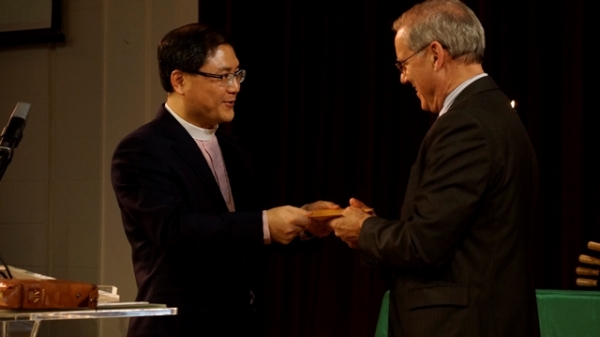 강원근 목사(좌)가 지난 2012년 제1회 선교대회에서 OMSC선교센터 총재 조나단 봉크 박사에게 격려금을 전달하고 있는 모습. 