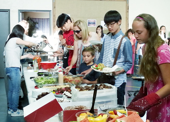 시미밸리에 있는 미국인 교회에서 열린 학예회에서 민박을 제공했던 가정의 식구들과 한인학생이 음식과 함께 사랑을 나누고 있다. 
