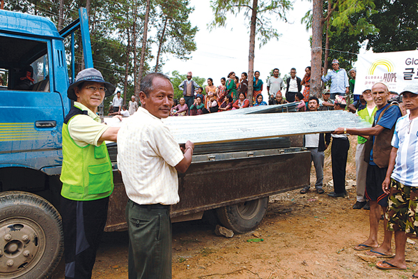 글로벌호프 대표 조용중 목사(맨 왼쪽)가 네팔 대지진 피해지역에서 우기에 대비한 거주지 복구에 필요한 양철을 차에서 내리고 있다.
