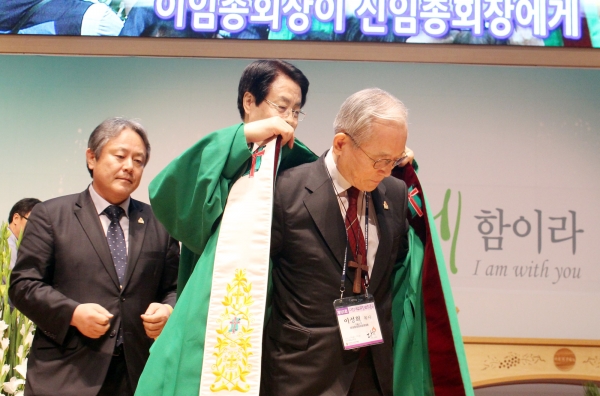 신임 총회장 이성희 목사(오른쪽)에게 전임 채영남 목사가 예복을 입혀주고 있다. ⓒ이대웅 기자